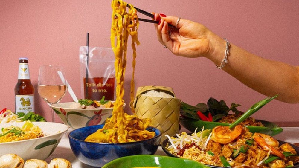 Hand using chopsticks to pick up noodles