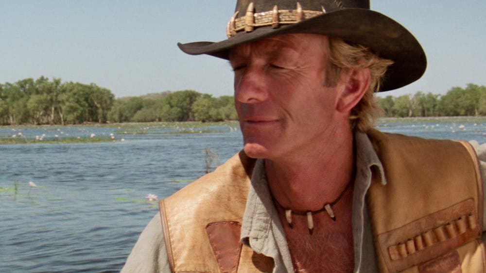 Man wearing an akubra with eyes closed, water in background