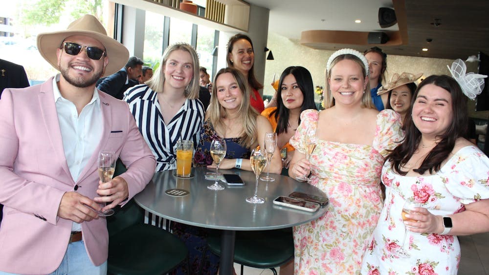An image of people smiling in racewear attire