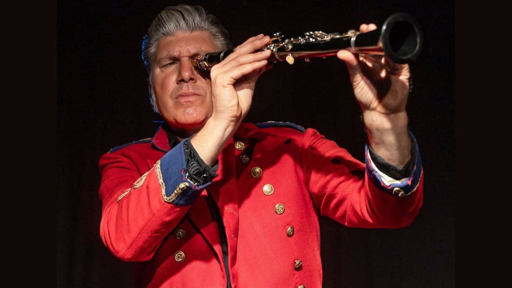 Mikelangelo holding up a clarinet as if using it as a telescope