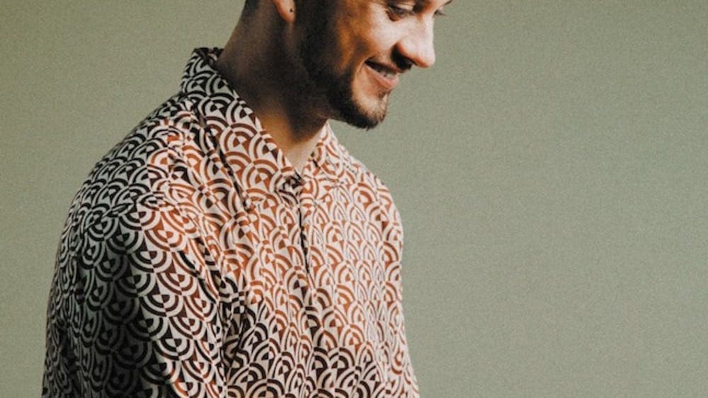 A man holding drum sticks and smiling