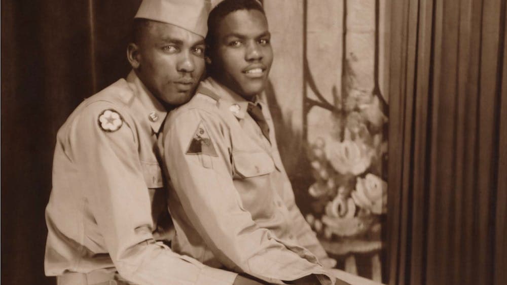 Archival image of two military men embracing in a pose looking at camera