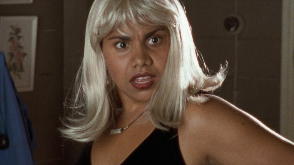 Woman looks surprised wearing a blonde wig and red lipstick