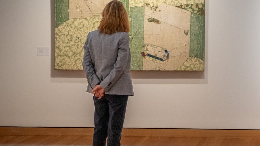 Woman observing artwork from Bruce Reynolds exhibition, 2024 at CMAG