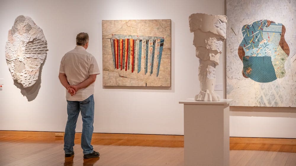 Man observing artworks from Bruce Reynolds ehxibition at CMAG, 2024