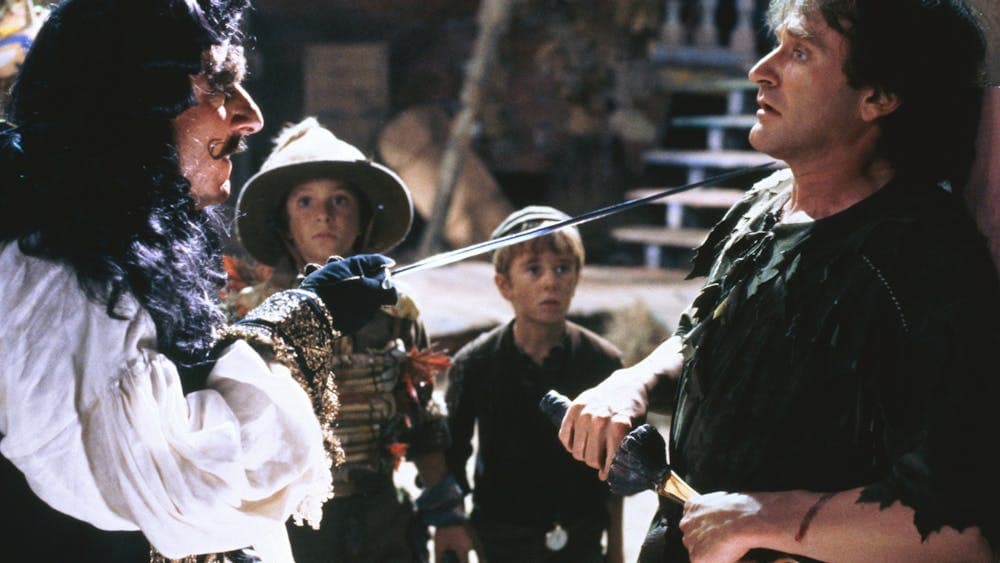 A pirate points a sword at a scared man with scared children in background