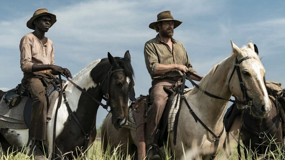 Two men on horseback in a field