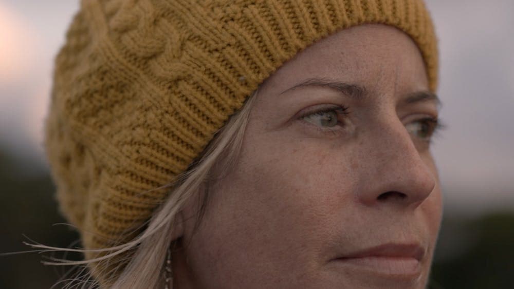 close up of woman looking to the side wearing a beanie