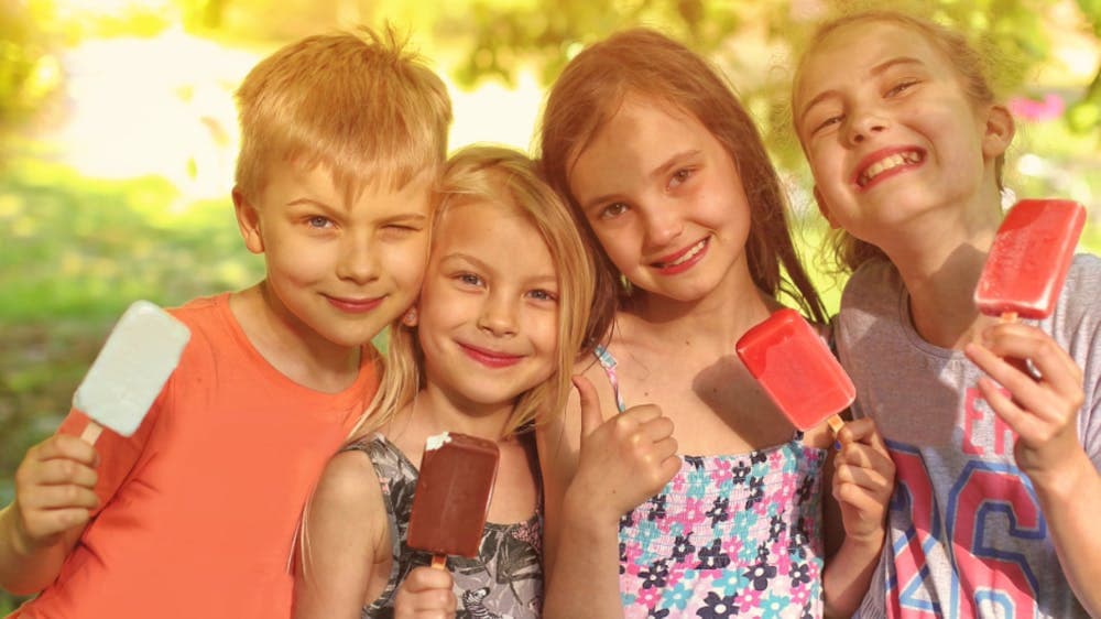 four children eating iceblocks smiling at the camera in Canberra for the Wonderful World Festival