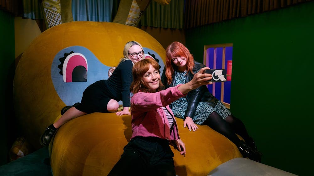 Three women posing on interactive artwork Bunny Dearest taking a selfie