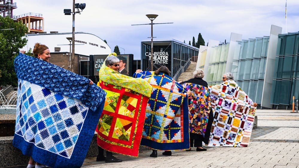 Canberra Quilters posing with quilts displayed at Civic Square