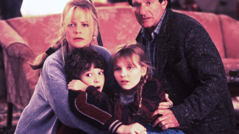A family of four looking past the camera, huddling together scared