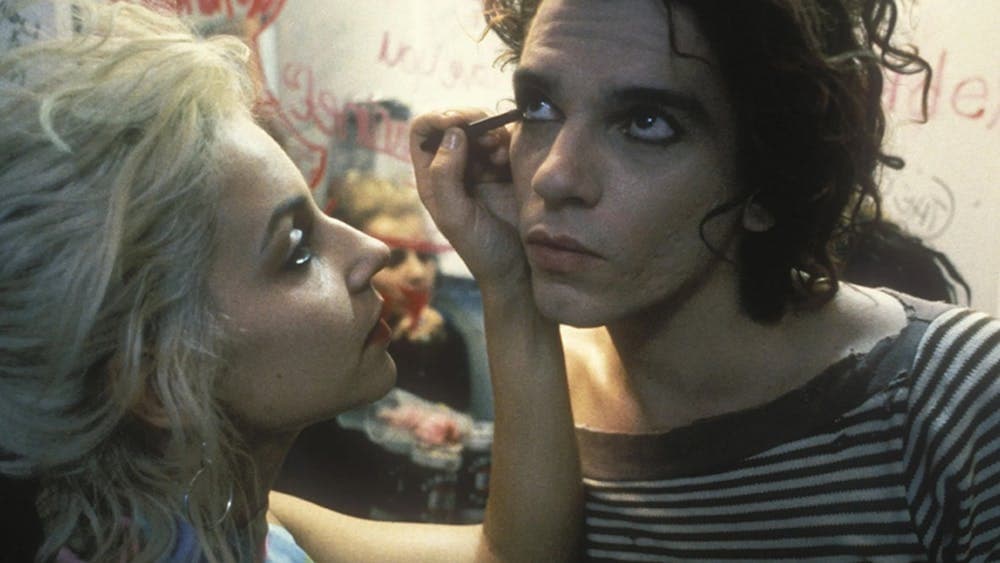 Woman applies eyeliner on man's bottom line