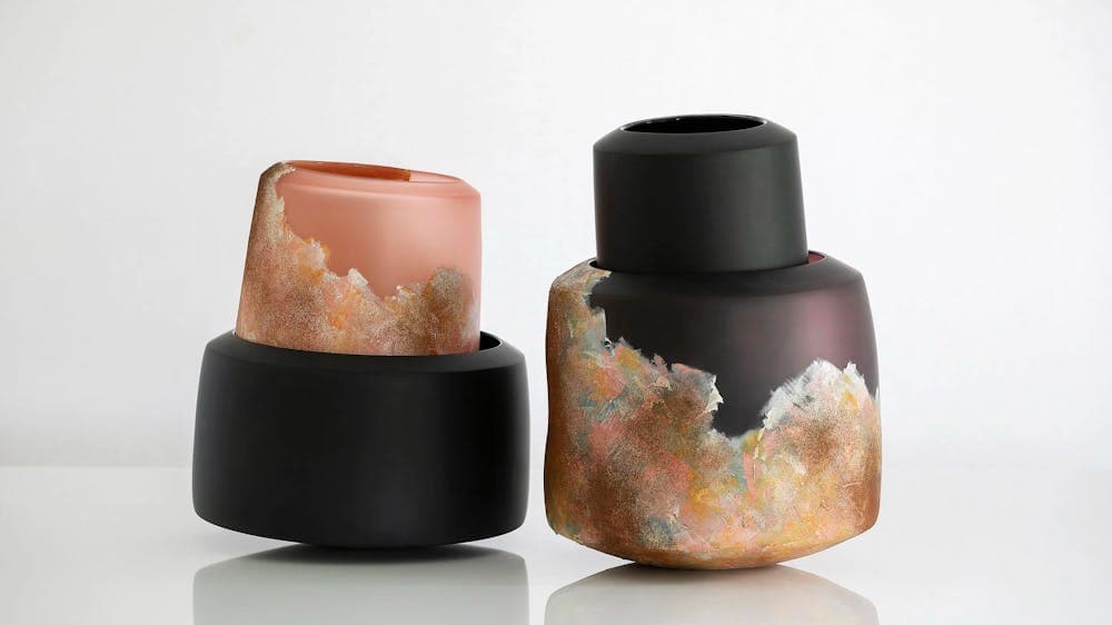 two glass objects, black and varyingshades of copper
