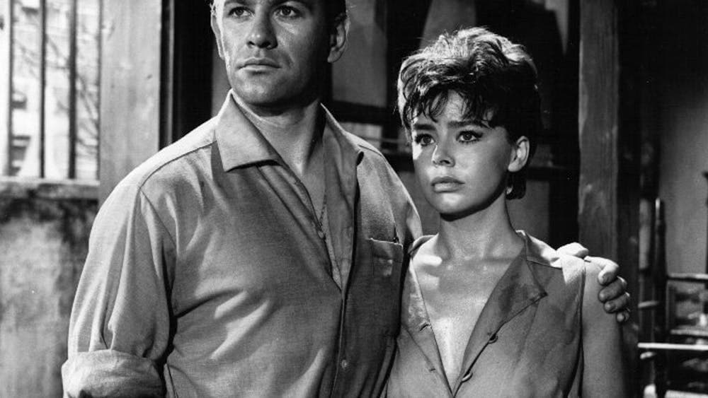 Black and white image of woman and man standing together looking forlorn past the camera
