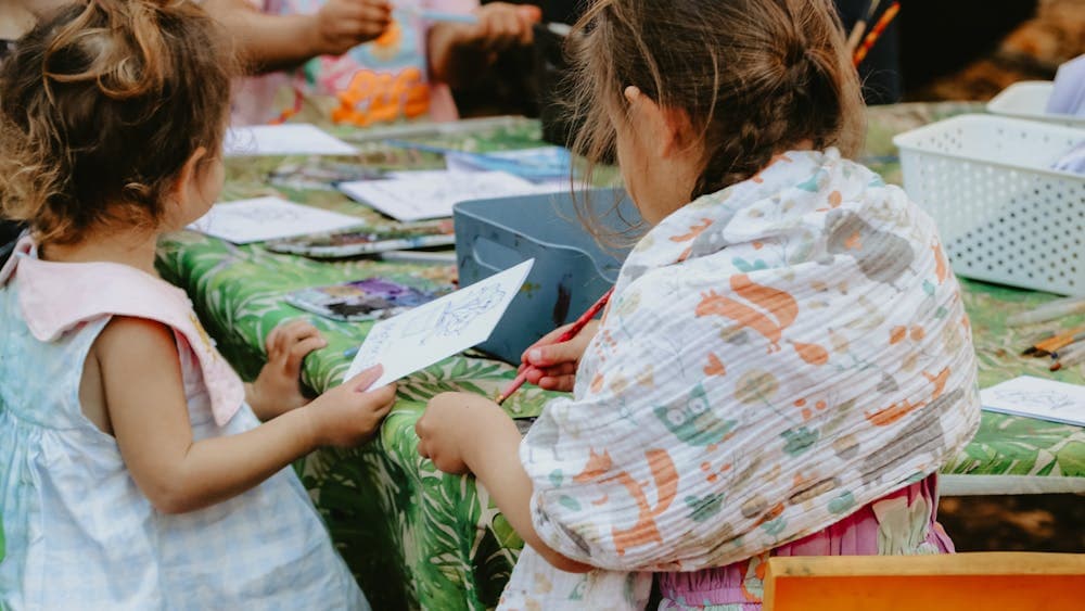 Children sitting around a table doing colouring in activities