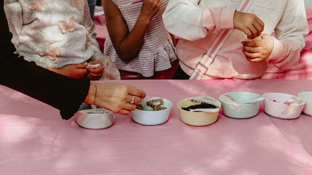 An image of potion ingredients on a table, with kids hands taking the ingredients.
