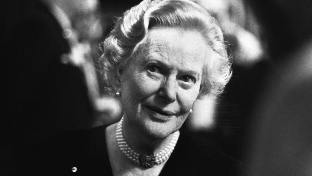 Older woman wearing pearls around neck looking past camera, black and white photo
