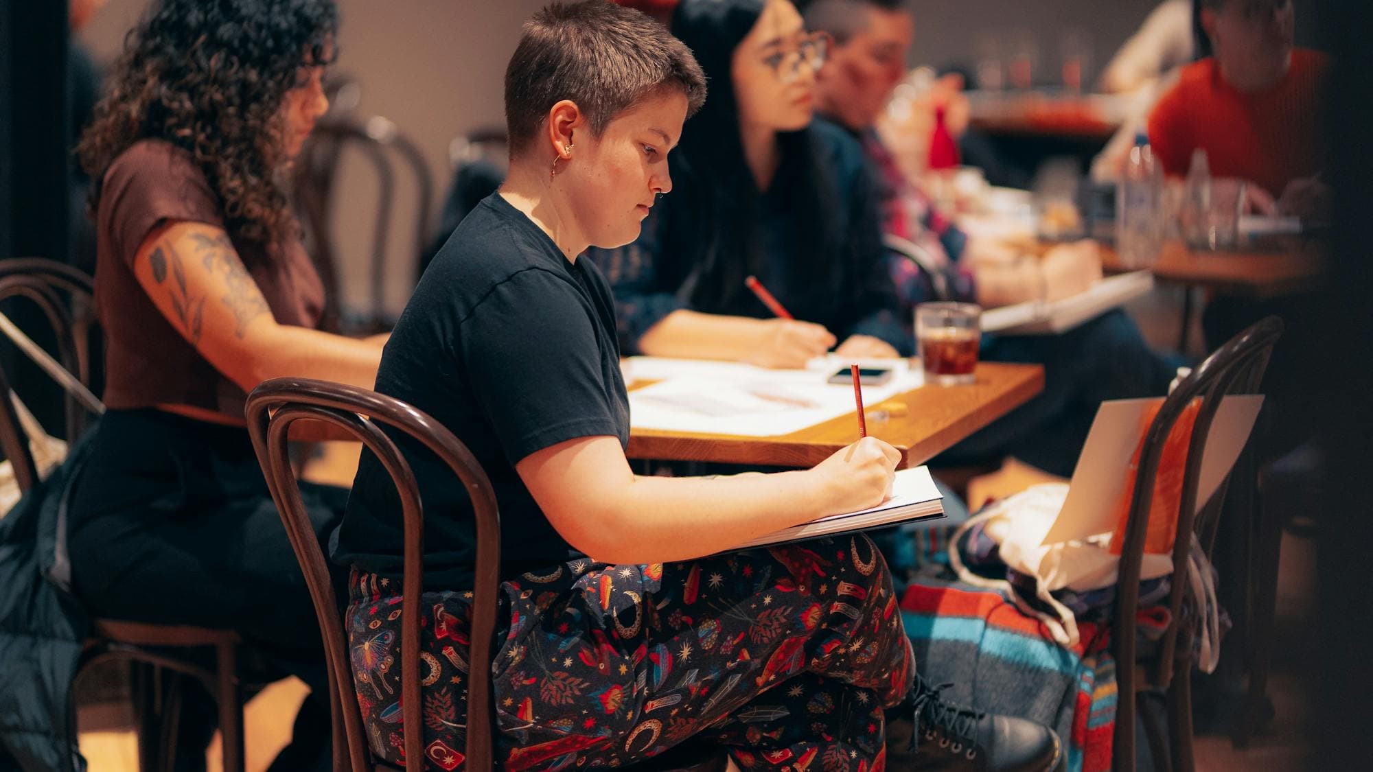 Group of people sitting around a table drawing
