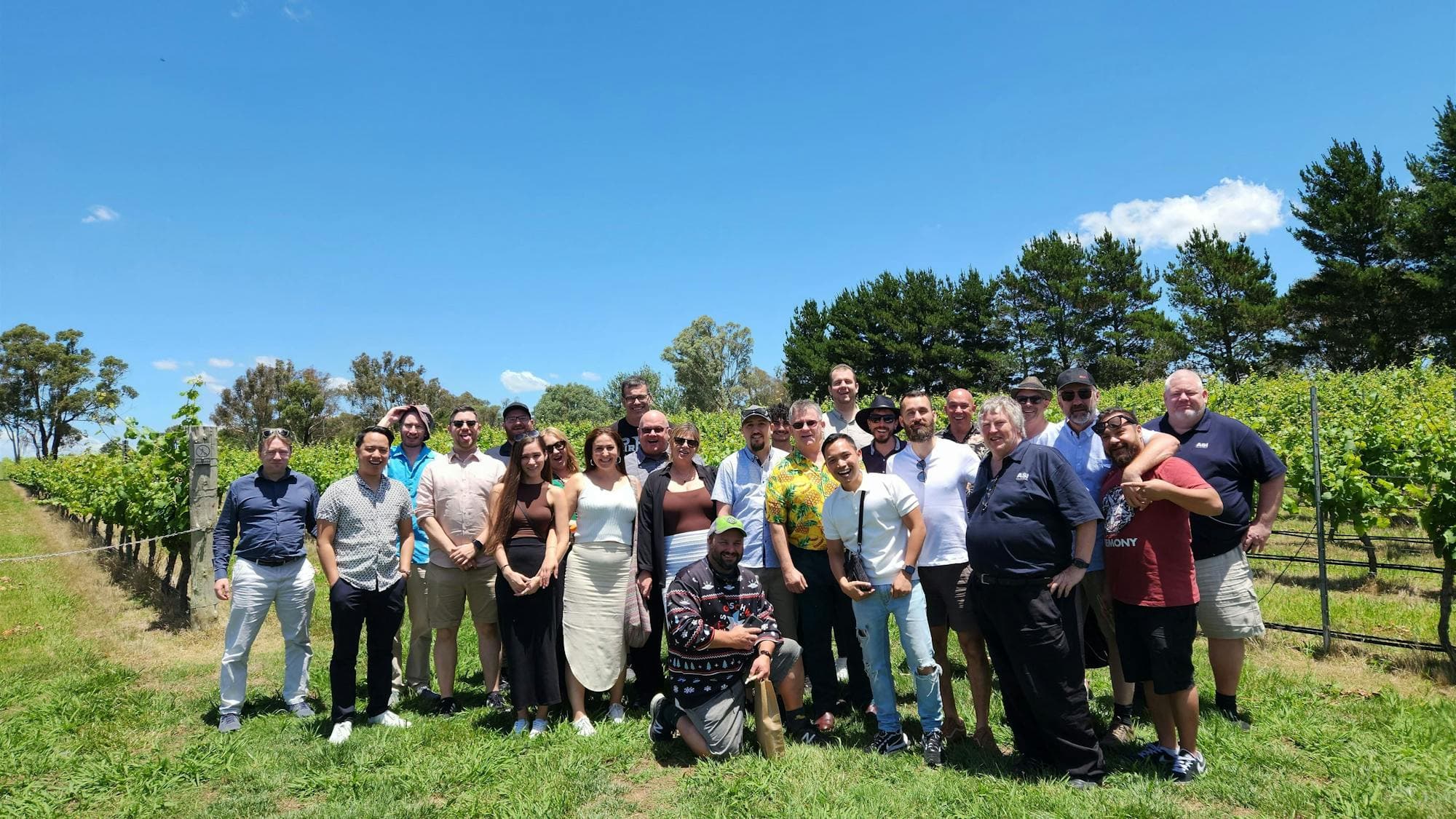A diverse group of individuals standing together in a vast field, showcasing unity and togetherness.