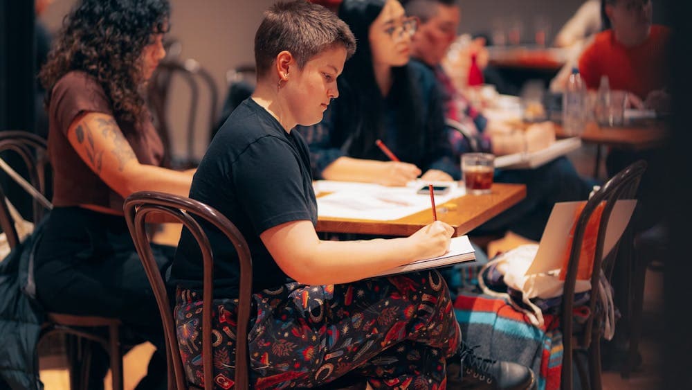 Group of people sitting around a table drawing