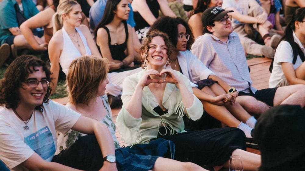 Image of people smiling and happy sitting on grass