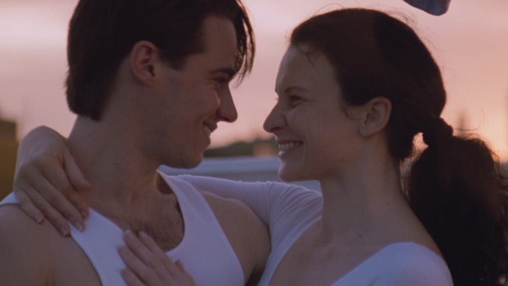 Woman and man embracing and smiling towards each other