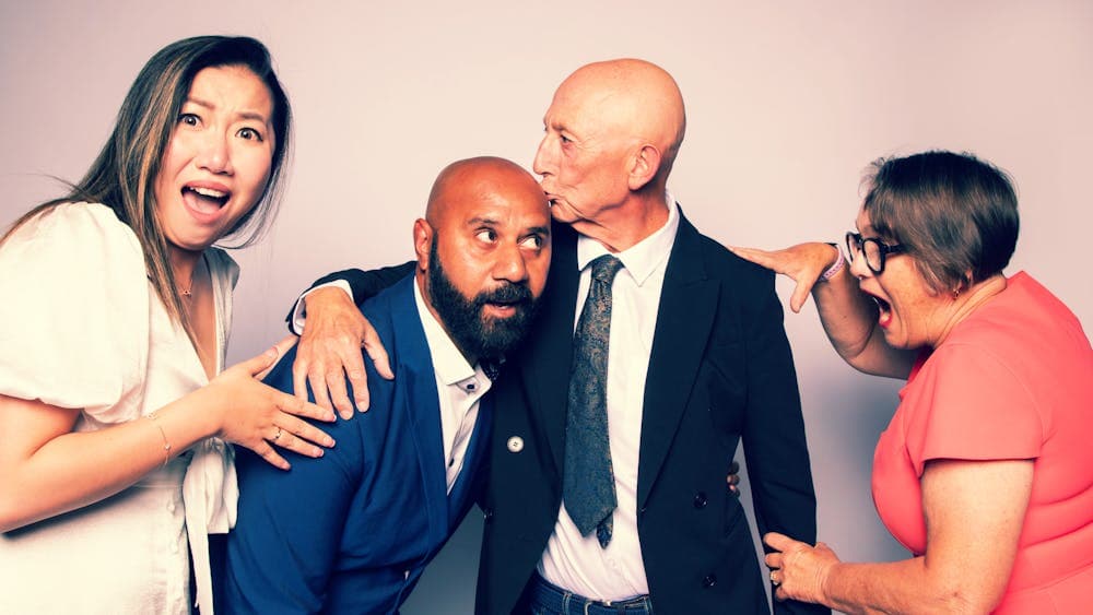 2 women and 2 men playing. Women looking shocked as men are kissing each other