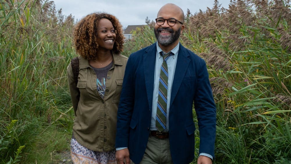 A woman and man walking through grassy fields laughing