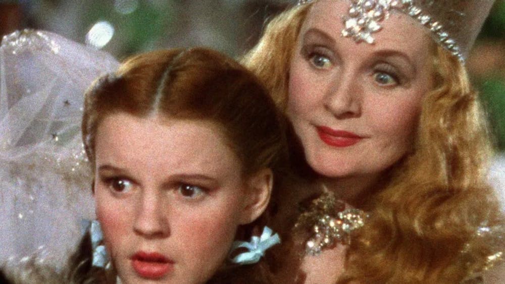 Young girl stares scared with a fairy leaning behind her