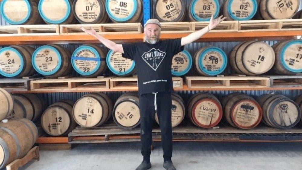Craft Works head distiller in front of casks