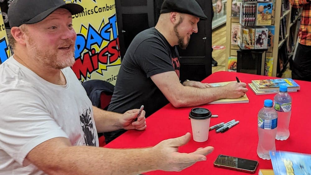 Two men sit at a table