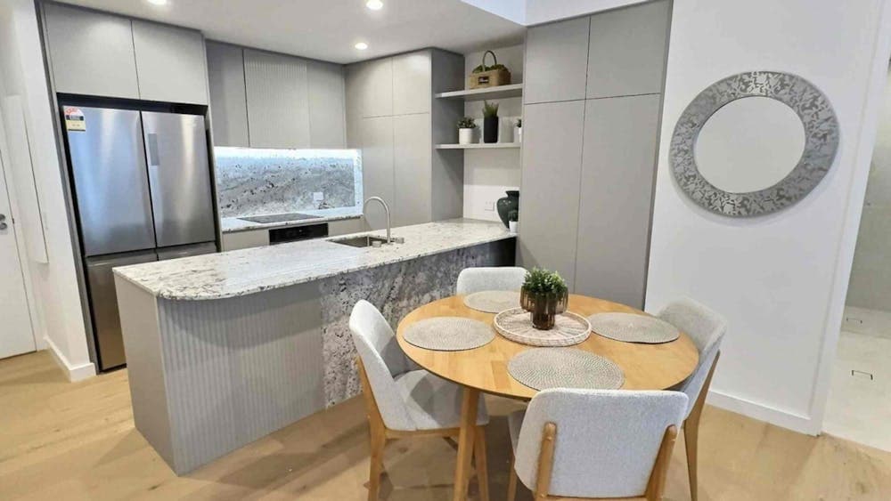 Close-up of a kitchen island counter paired with a wooden dining table setup.
