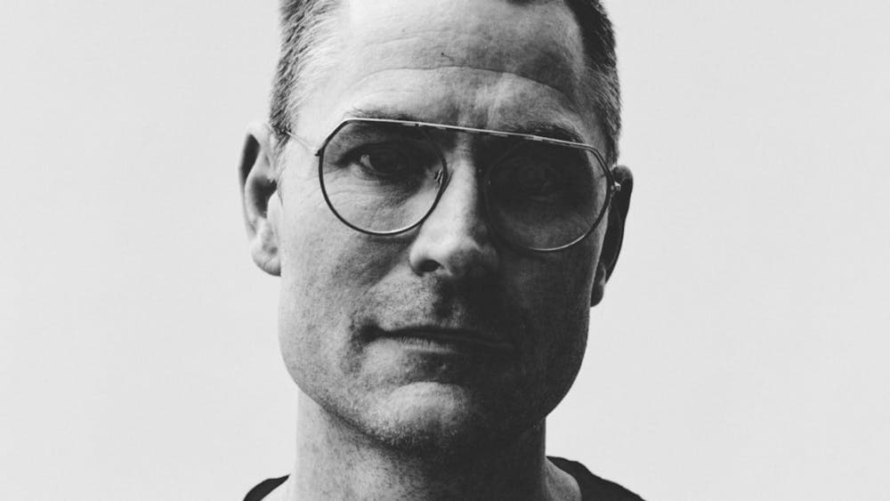 Black and white image of man wearing glasses looking at camera