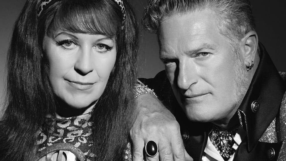Black and white image of man and woman posing and looking at camera