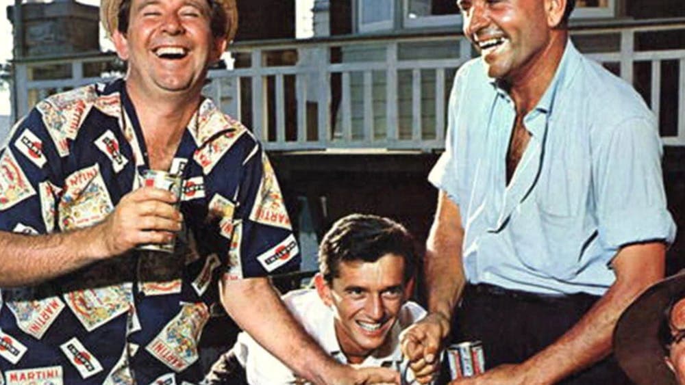 Three men laughing and drinking at the beach