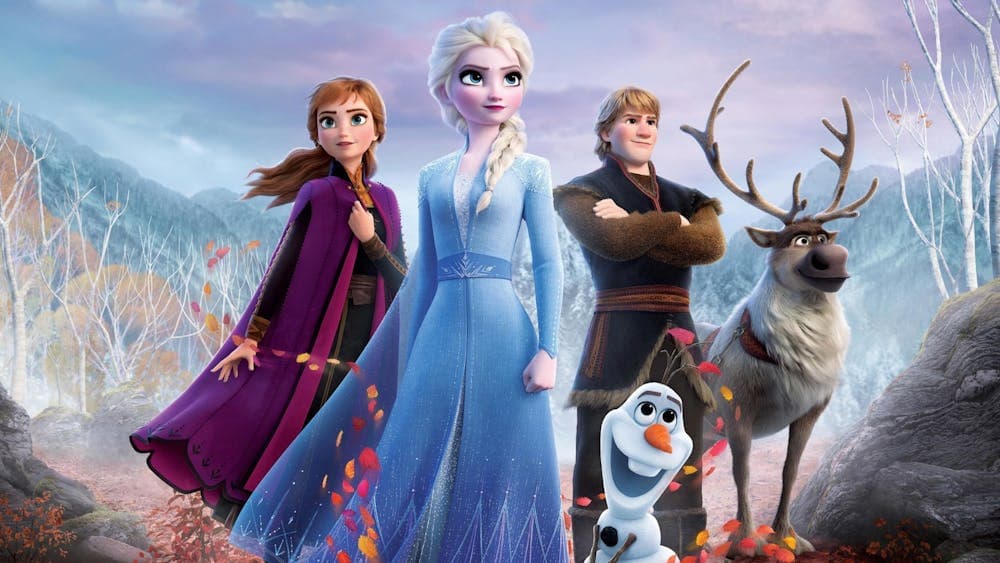 Two women, one male figure with a snowman and deer looking proud standing together