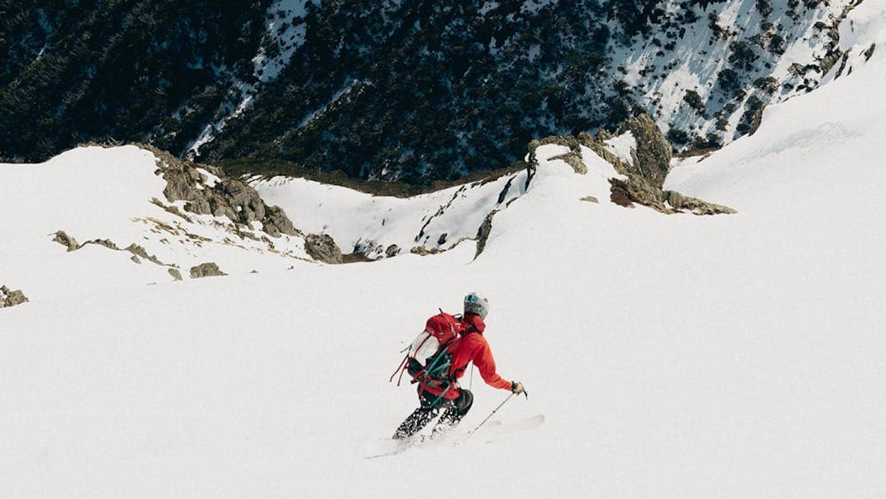 Wide snow mountain photo with man skiing downhill