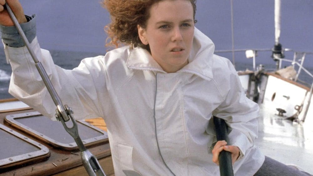 Woman on a yacht with curly red hair blowing in the wind