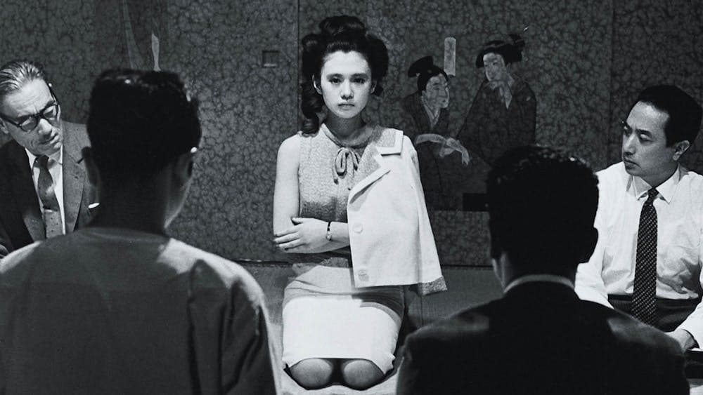 Black and white image of woman kneeling on floor with arms crossed