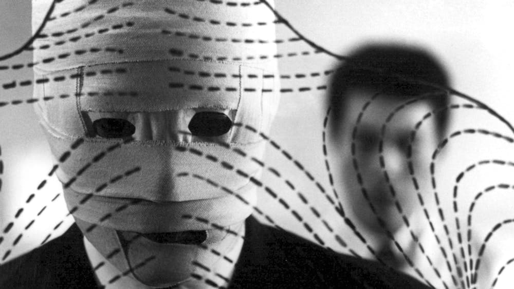 Black and white image of man with face covered in bandages