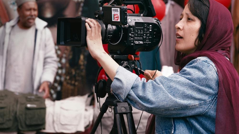 Woman behind a large film camera in action