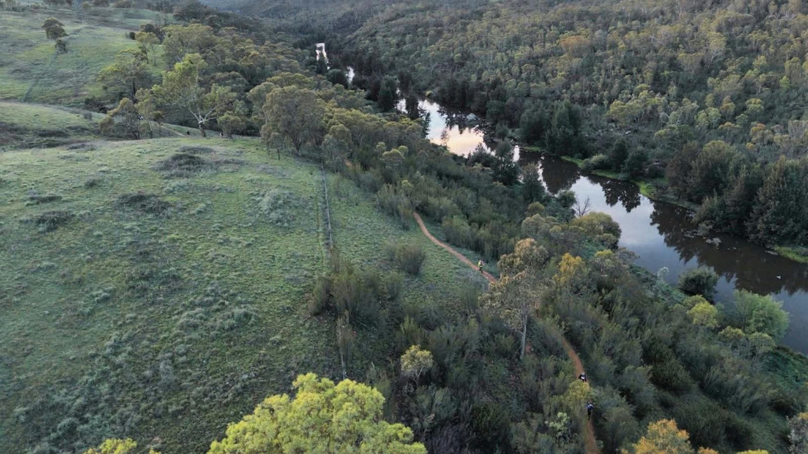 an arial photo of bushland and a river